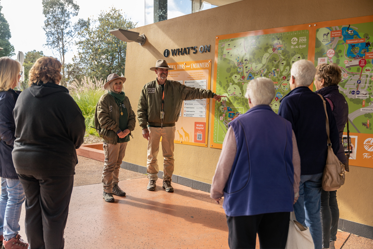 Group of guests being shown the large Taronga Western Plains map on the wall