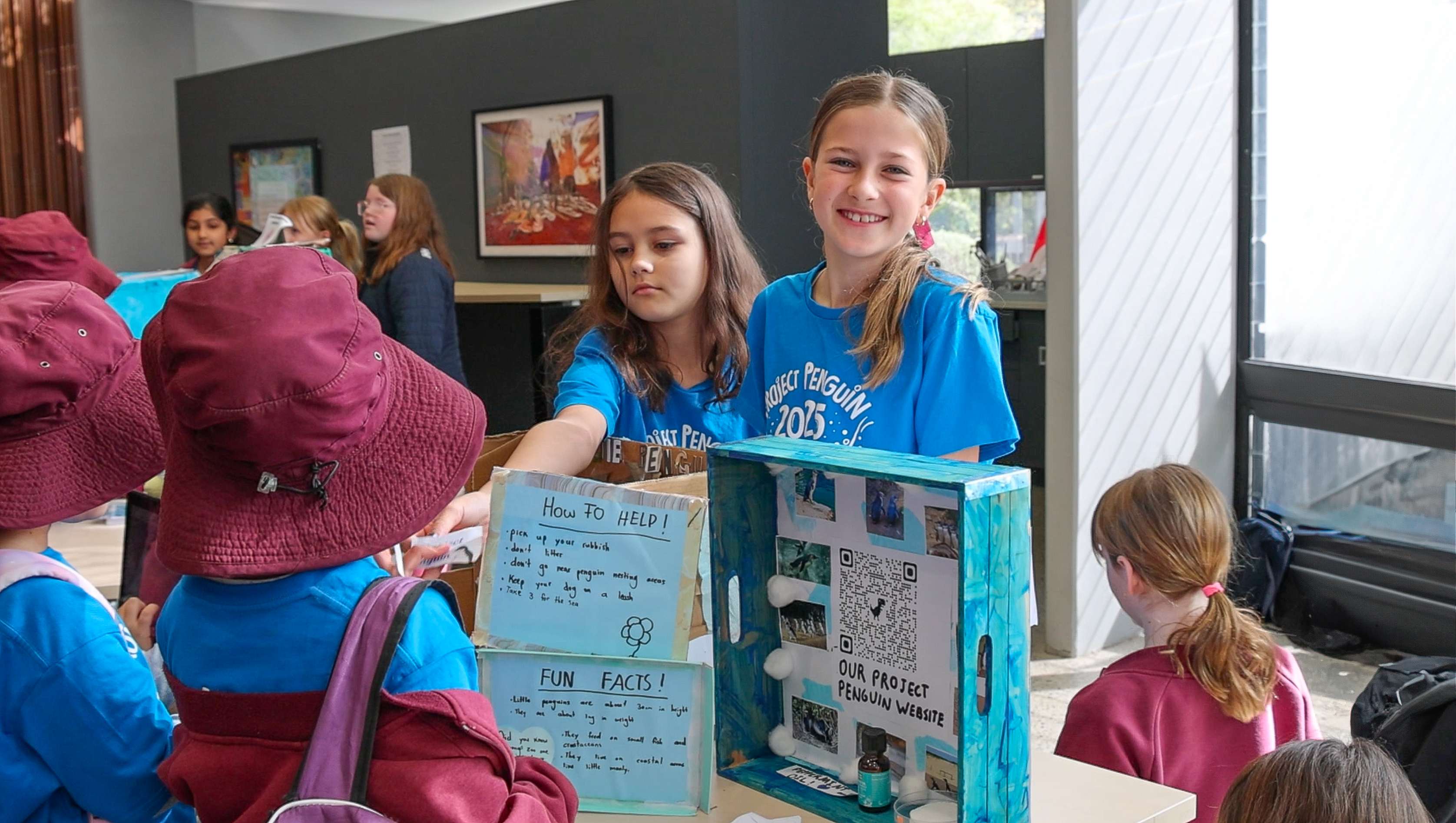 School students presenting a penguin project during an interactive education session.